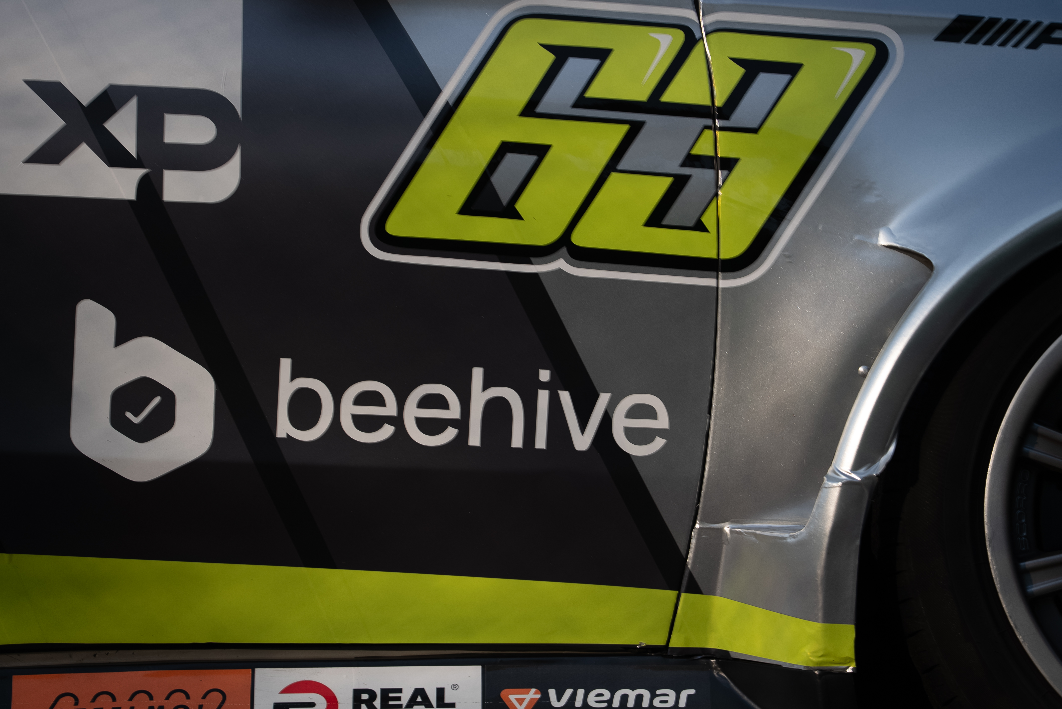Detalhe em close da marca “beehive” aplicada na lataria do carro.