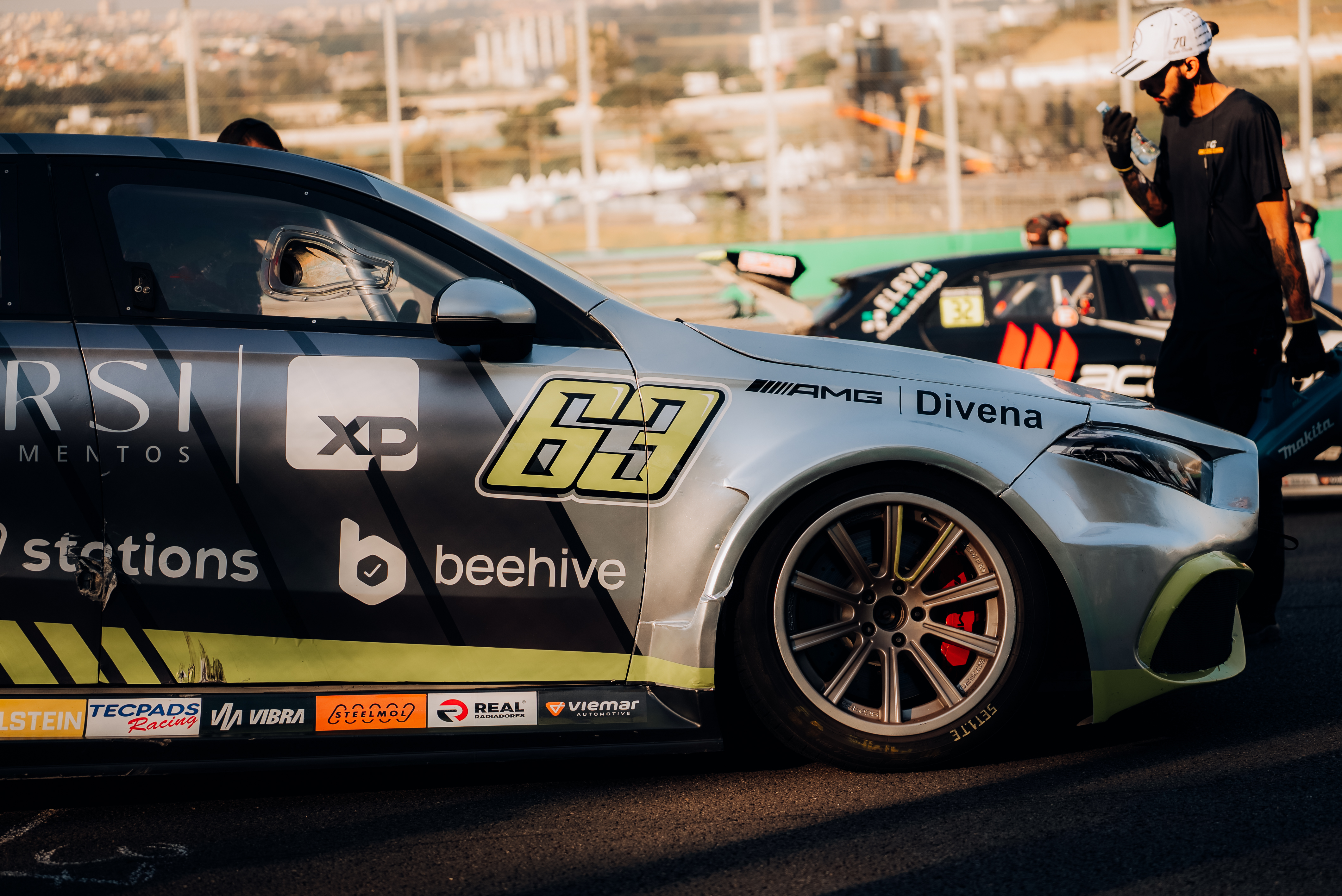 Lateral do carro de corrida com a marca “beehive” aplicada, na pista de Interlagos.
